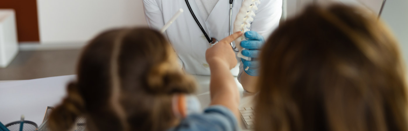 2 children pointing at spine